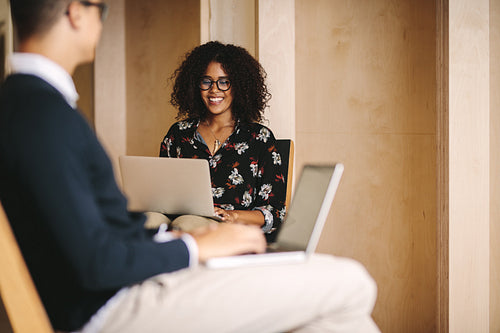 Business colleagues working on laptops in office