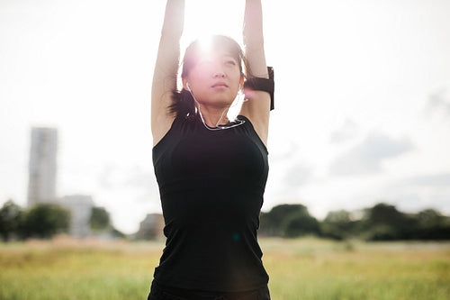 Fitness female stretching hands at park