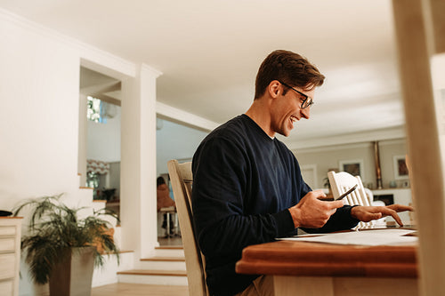 Smiling man working on laptop at home
