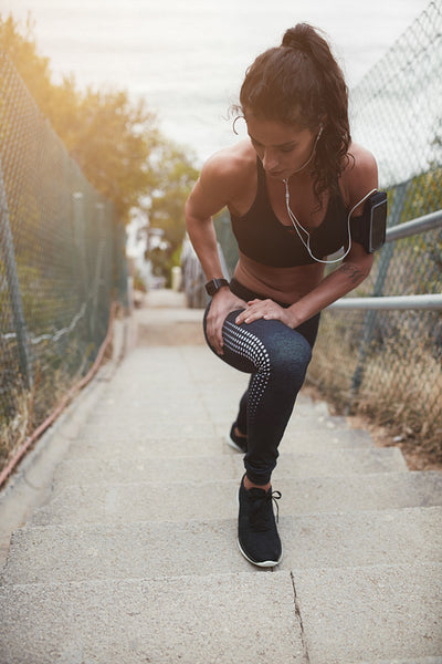 Young woman stretching her legs on steps