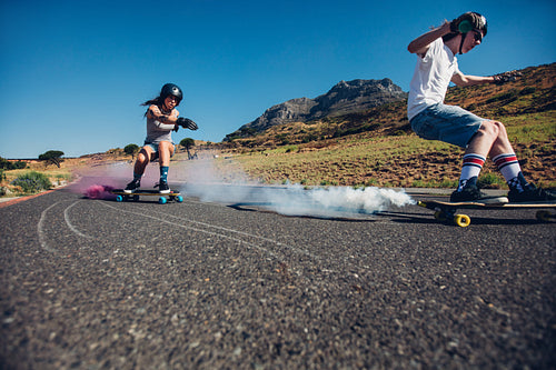 Teenagers longboarding on open road