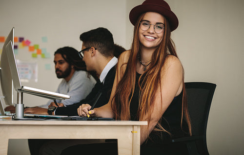 Smiling businesswoman sitting at her desk in office
