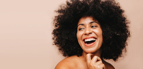 Beautiful woman with Afro hair laughing cheerfully in a studio