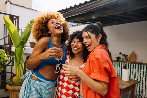 Three cheerful young women enjoying an outdoor gathering together