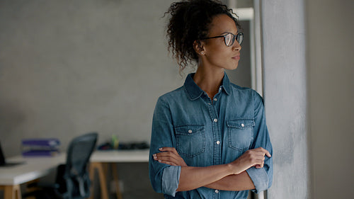 Thoughtful businesswoman looking out of her office window