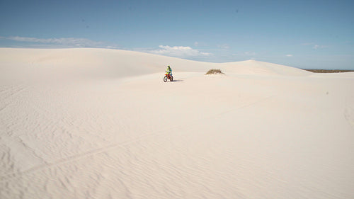 Motorcyclist jumping obstacles in a desert