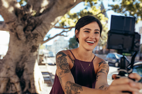 happy young woman vlogging outdoors