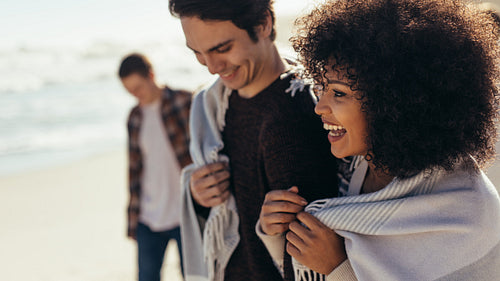 Smiling woman walking on the beach with boyfriend