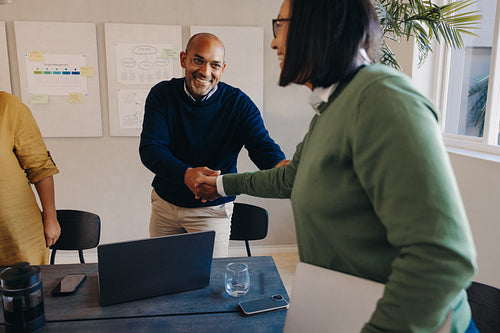 Professionals shaking hands during a client meeting in a business environment