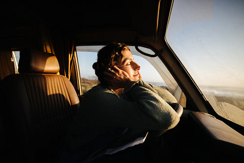 A peaceful moment as a traveler rests with her head on her hands in the car