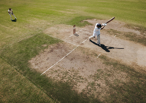 Batsman swinging the bat during a cricket match on the field