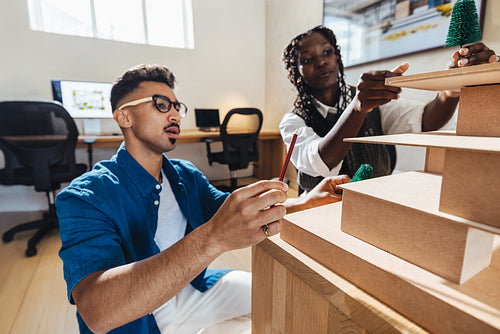 Young architects working on architectural models in a creative office space