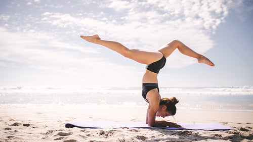 Sporty girl doing handstand yoga asana