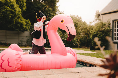 Boy pretending to be a pirate playing in the pool