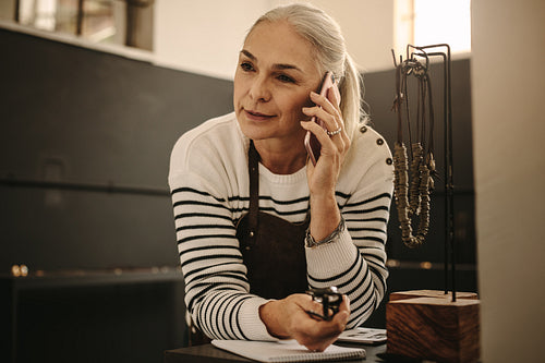 Jeweler in her workshop making a phone call