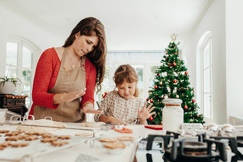 Mother and daughter making Christmas cookies.