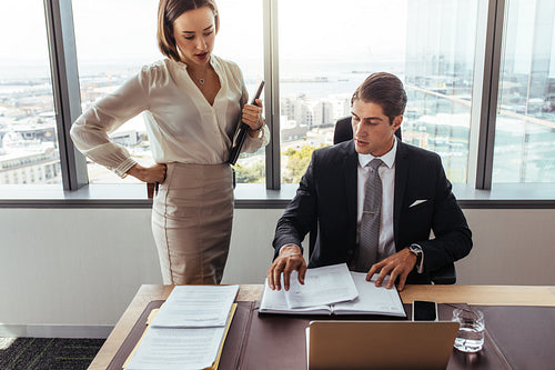 Business people discussing contract documents in office