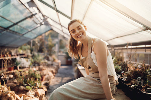 Beautiful gardener smiling at plant nursery