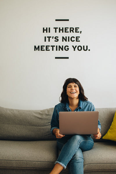 Cheerful businesswoman on sofa with laptop in office