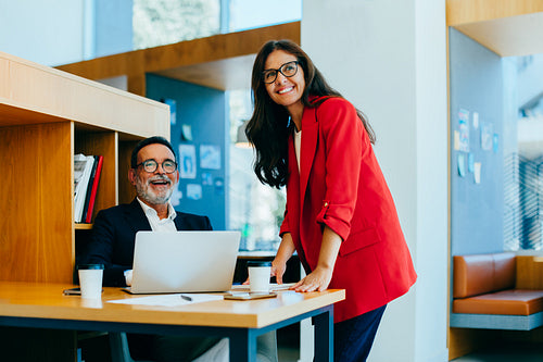 Smiling colleagues engaging in a productive discussion in a professional office setting