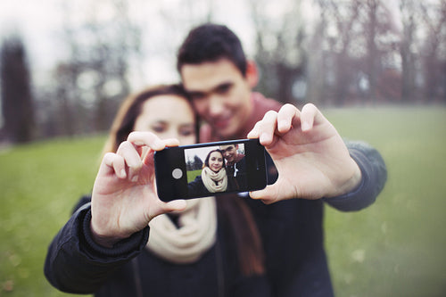 Cute young couple taking a self-portrait with mobile phone