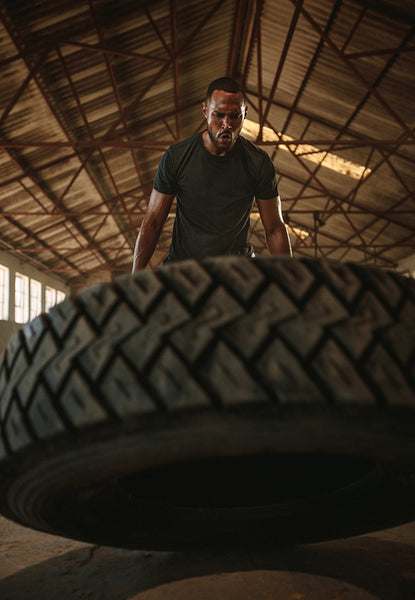 Muscular man doing cross training inside old warehouse