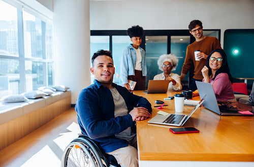 Business teamwork: Wheelchair user contributes during a group meeting