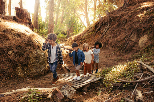 Group of children building camp in forest