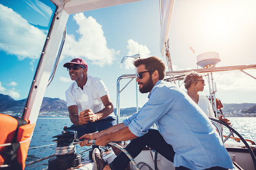 Men using a winch to tighten the line to a sail
