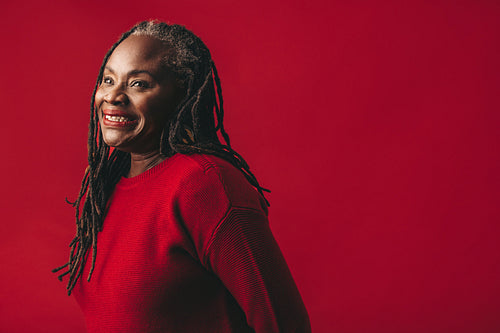 Beautiful woman with dreadlocks smiling happily in a studio