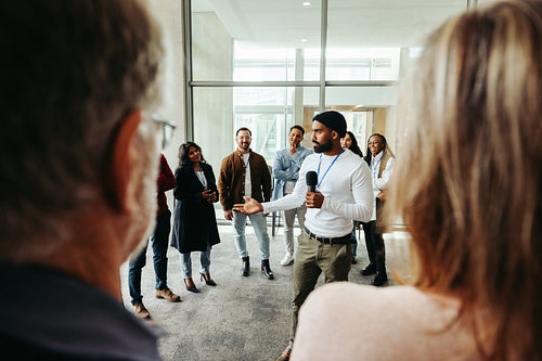 Instructor speaking during seminar in modern office with diverse audience