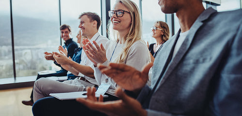 Audience applauding during a business conference presentation