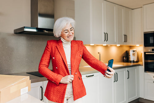 Stylish senior woman showing off her new jacket on a video call