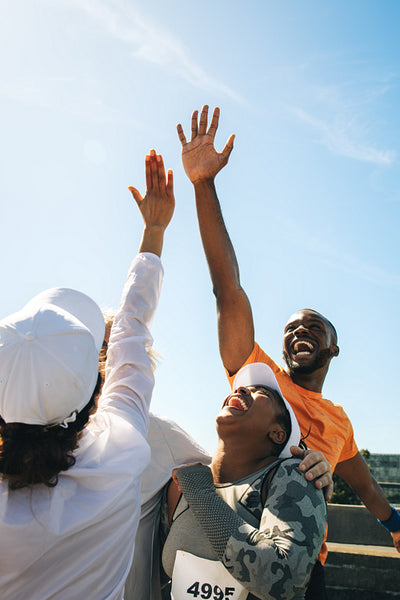 Joyful marathon participants celebrate with high fives and laughter