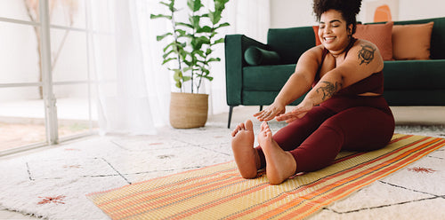 Happy fitness woman stretching at home