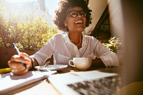 African woman working from a coffee shop