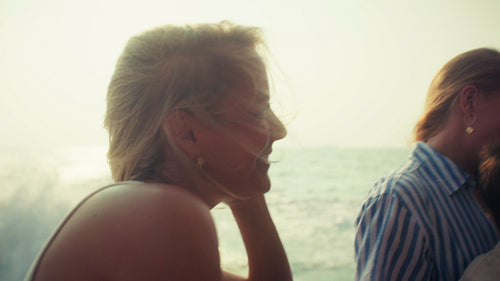 Happy woman relaxing on a boat during a sunset ocean cruise