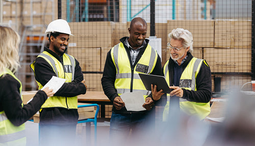 Successful warehouse team reading some reports during a meeting