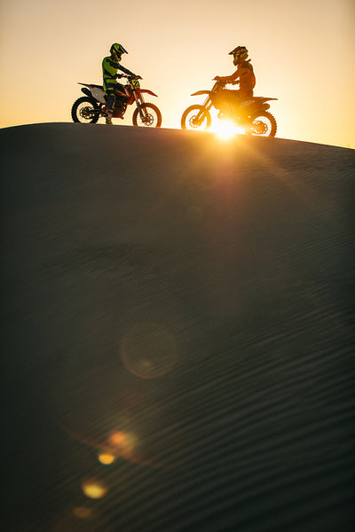 Motocross bikers on their racing bikes in a desert