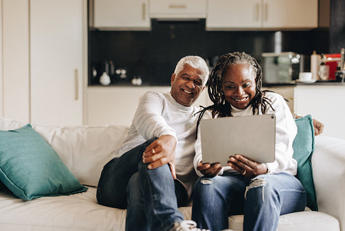 Happy mature couple having a video call on a digital tablet