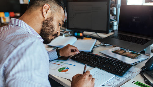 Businessman making notes at his office desk.