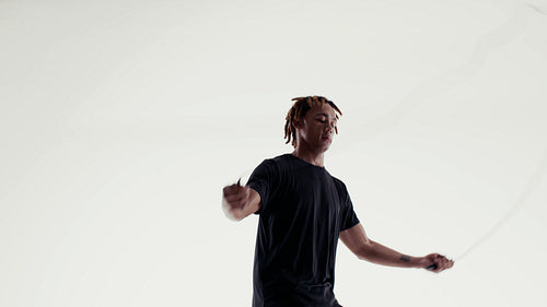 Dynamic athlete performs intense jump rope workout on a clean white studio background