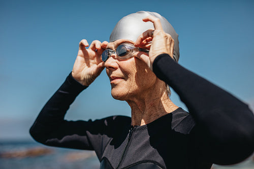 Senior woman getting ready to swim in the sea