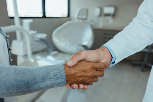 Shaking hands in a medical office symbolizes trust and partnership