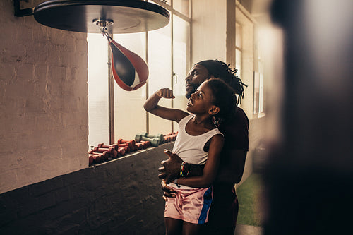 Coach training a kid on speedball punching