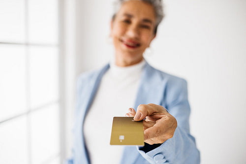 Professional banking: Senior business woman making a payment with a gold credit card