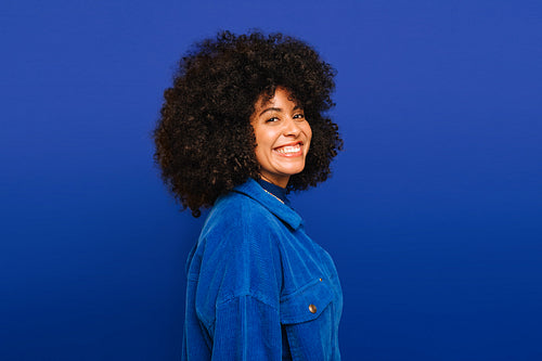 Portrait of a happy woman smiling at the camera against a blue background
