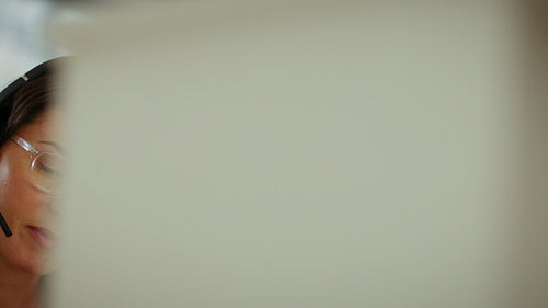 Female sales professional talking on a headset while working in an office