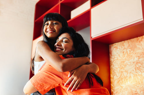 Latin American mother and daughter happily embracing each other