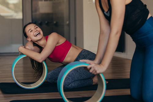 Pilates women at a gym holding a yoga or pilates wheel 